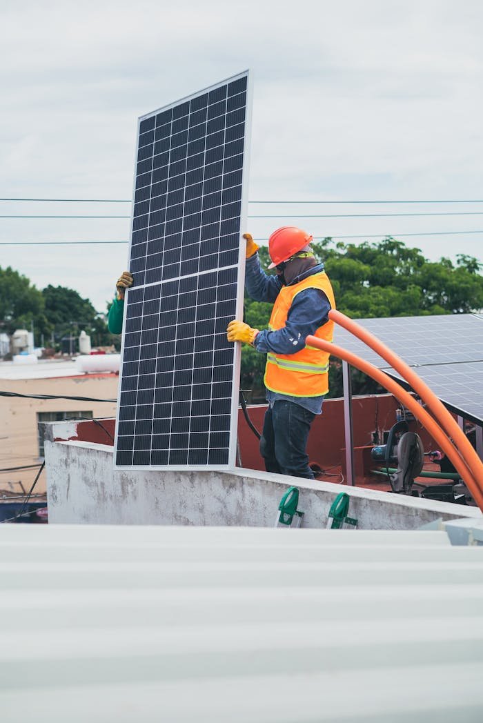 our-story A technician in safety gear installs a solar panel on a rooftop, promoting renewable energy.